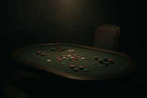 Table de poker vide avec des jetons éparpillés, dans une lumière tamisée