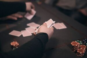 Des gens jouent au poker avec des cartes et jetons sur la table