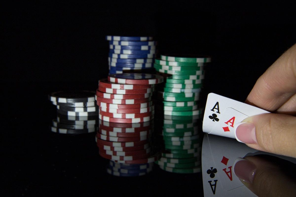 Jetons de poker et paire d’as en main, symbole de la victoire d’Alexis Nicolai au PokerStars Open EPT Barcelone 2025