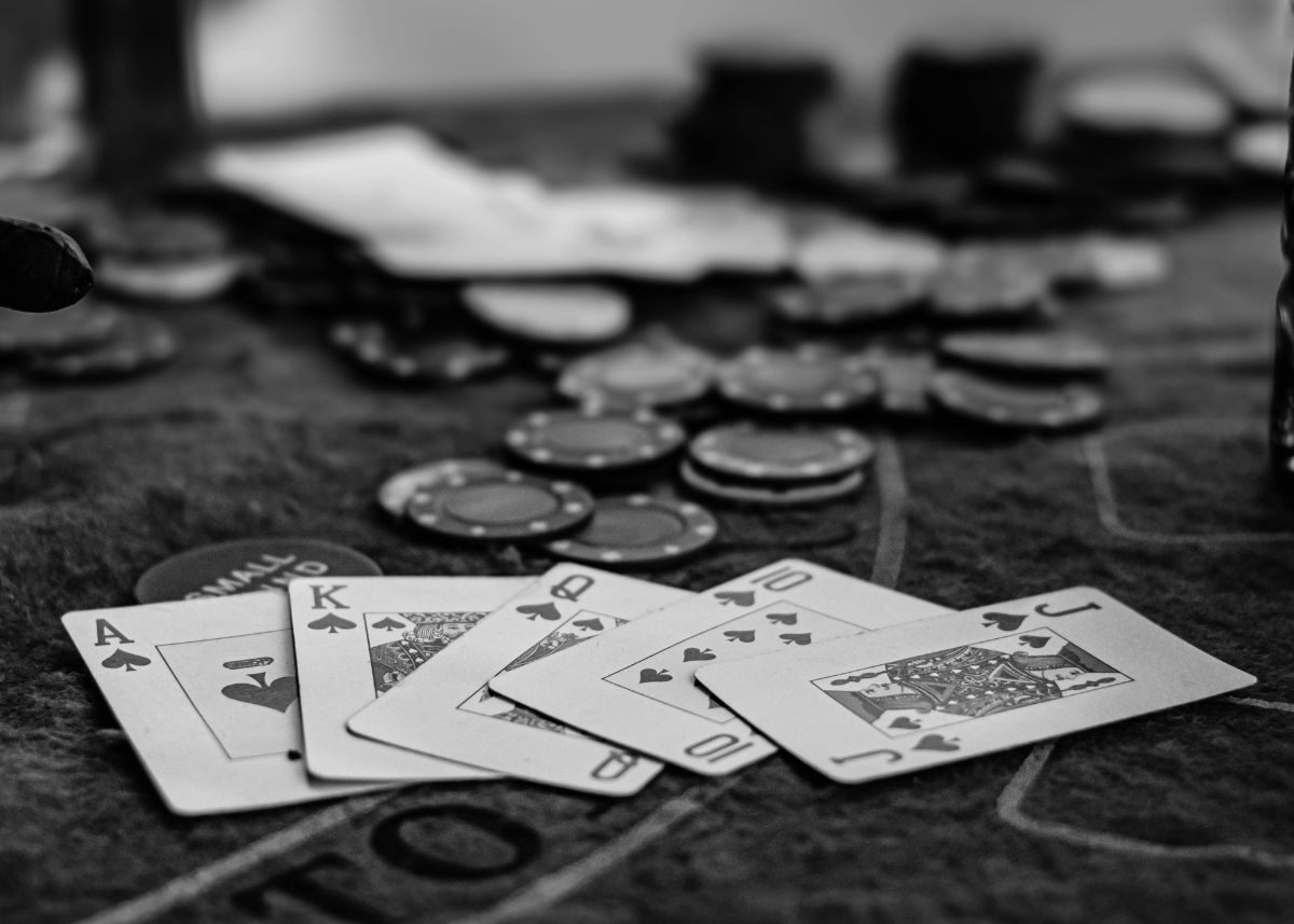 Main gagnante de poker sur une table de casino, entourée de jetons de mise.