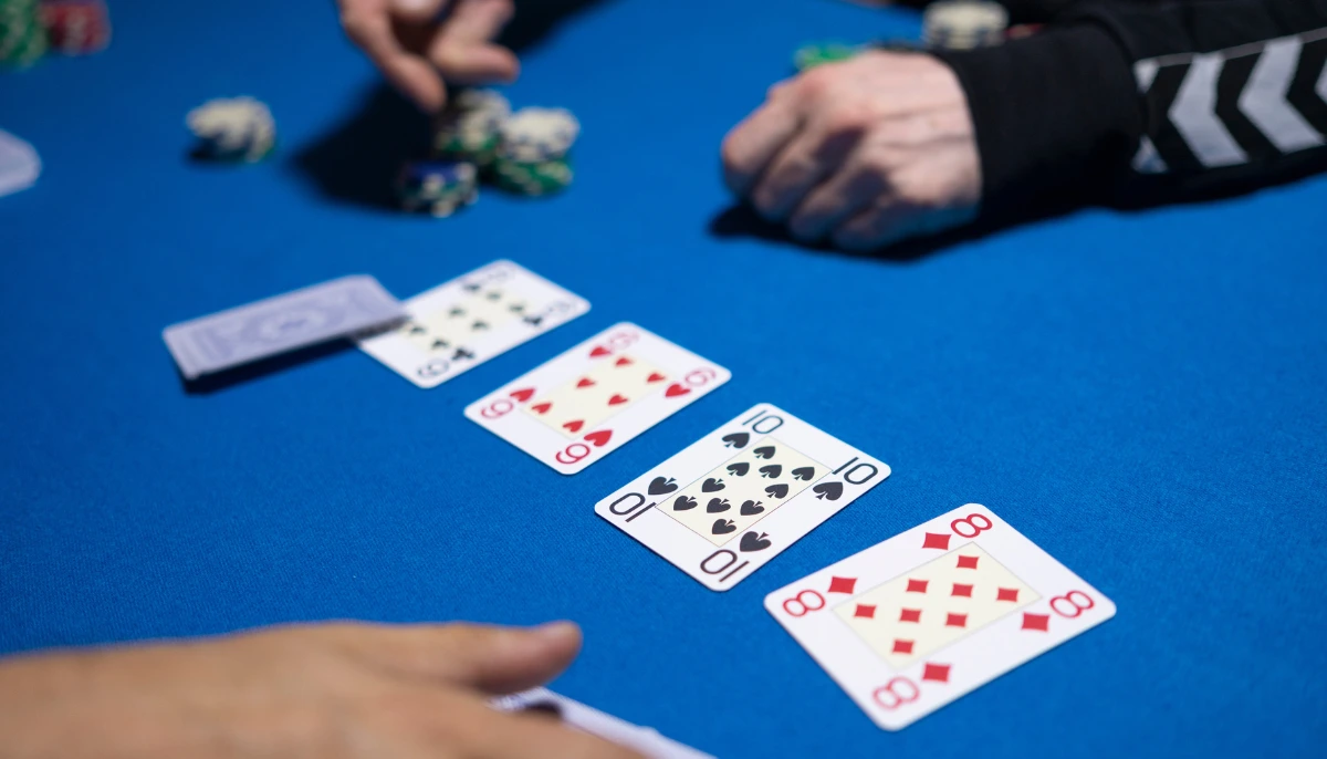 Bild på en dealer som delar ut kort till spelare vid ett pokerbord