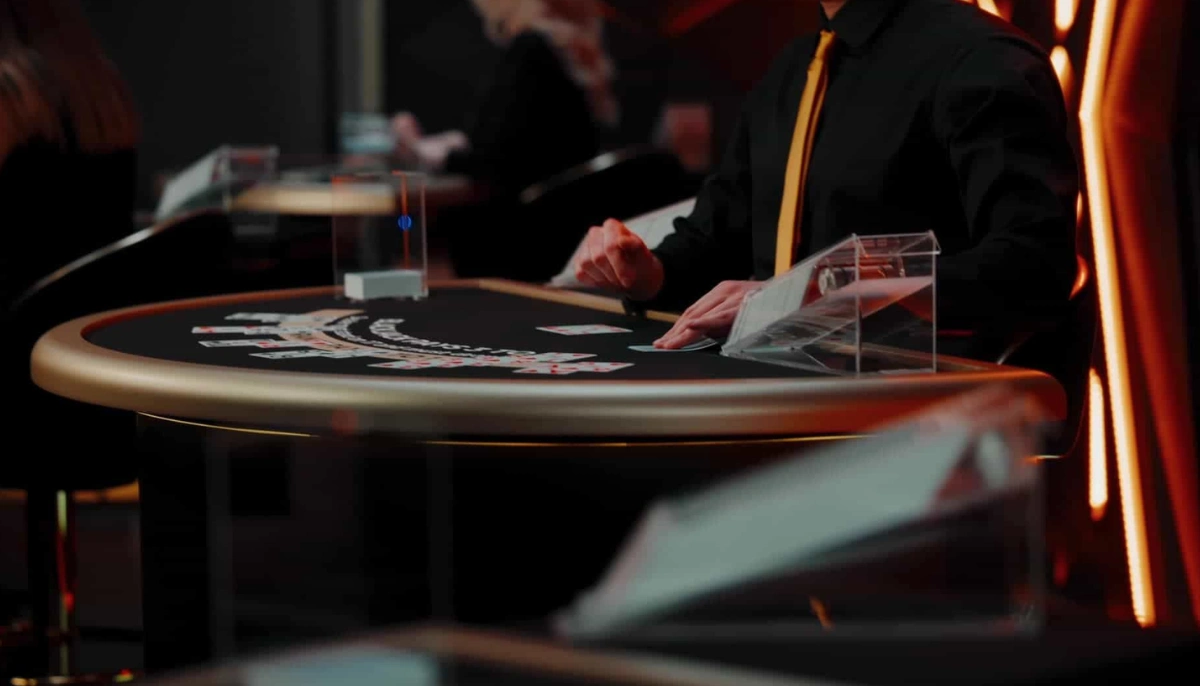 Live dealer delar ut kort vid ett casinobord i Evolutions studio.