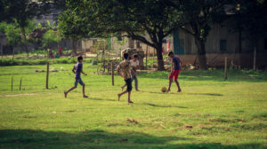 Middle Eastern kids playing soccer together in a village.