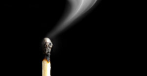 Extinguished wooden match with blowing trail of smoke