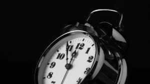 An alarm clock ticking towards a 12 o'clock deadline.