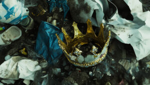 A gold crown lying in a heap of garbage.
