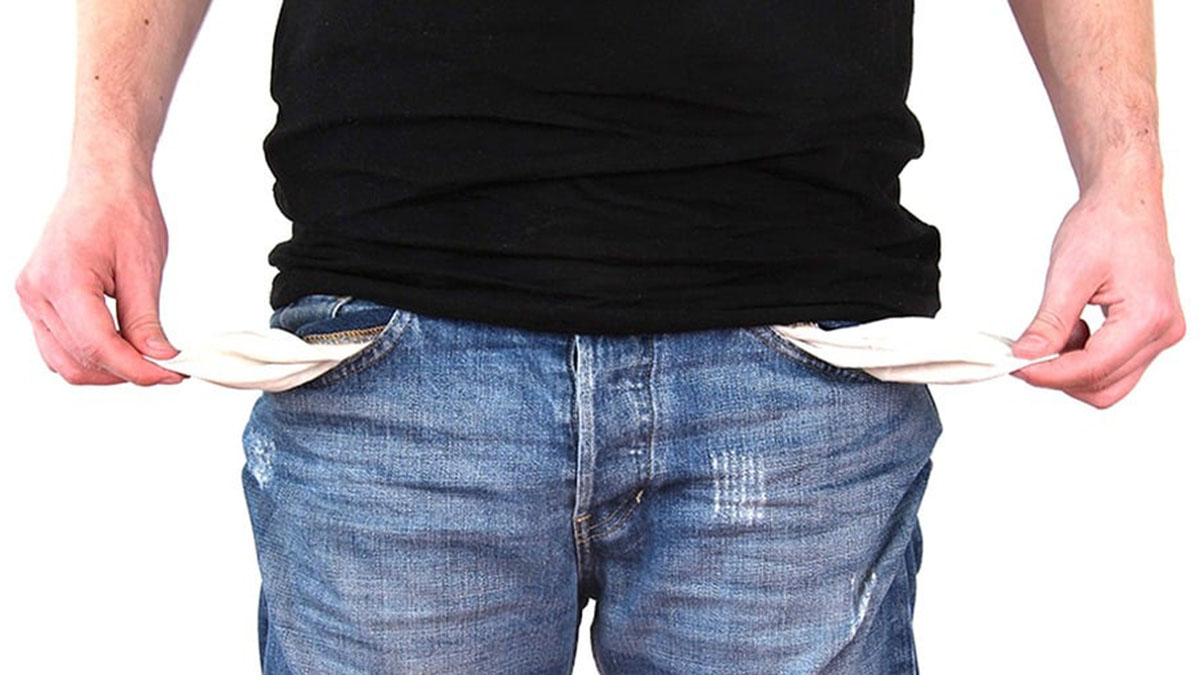 Man with no money turning out his empty pockets