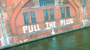 Street art seen in Berlin, reading "PULL THE PLUG"