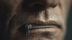 A man's face with mouth zippered shut.