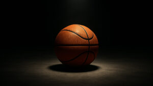 A basketball under the spotlight in a darkened room.