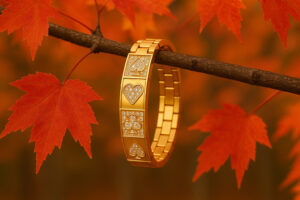 A WSOP-inspired gold bracelet hanging from a maple branch showing fall colors.