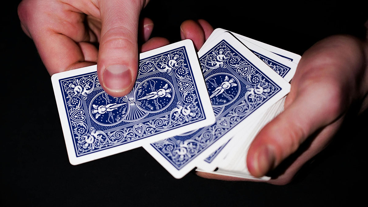 Poker dealer dealing cards off the top of a shuffled deck
