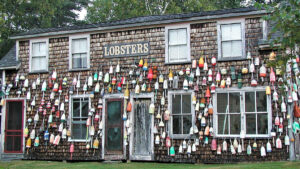 An old house in Maine, covered with buoys and a sign reading "LOBSTERS"