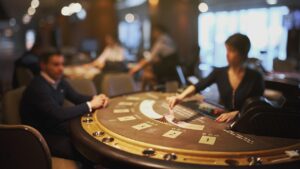 A photo of a blackjack table in a casino with the faces blurred.