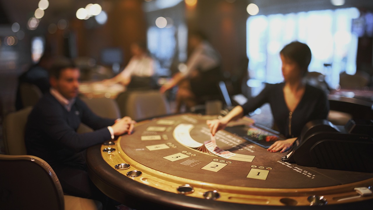 A photo of a blackjack table in a casino with the faces blurred.