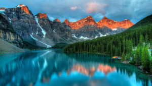 A lake in the Alberta Rockies, with sunset-lit mountain peaks in the background.