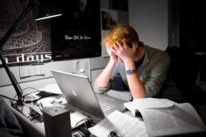 A man sitting at his computer, frustrated