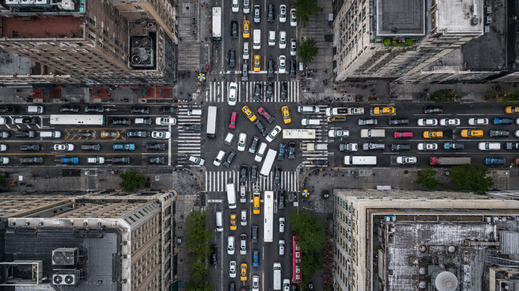 Birds-eye view of a downtown intersection with heavily gridlocked traffic.