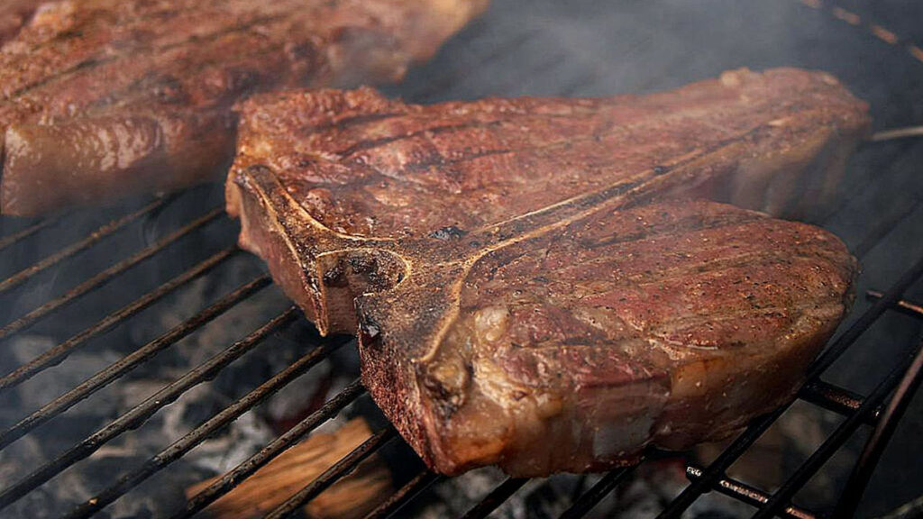A porterhouse steak on the grill.
