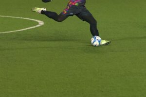 A soccer player kicking a ball.