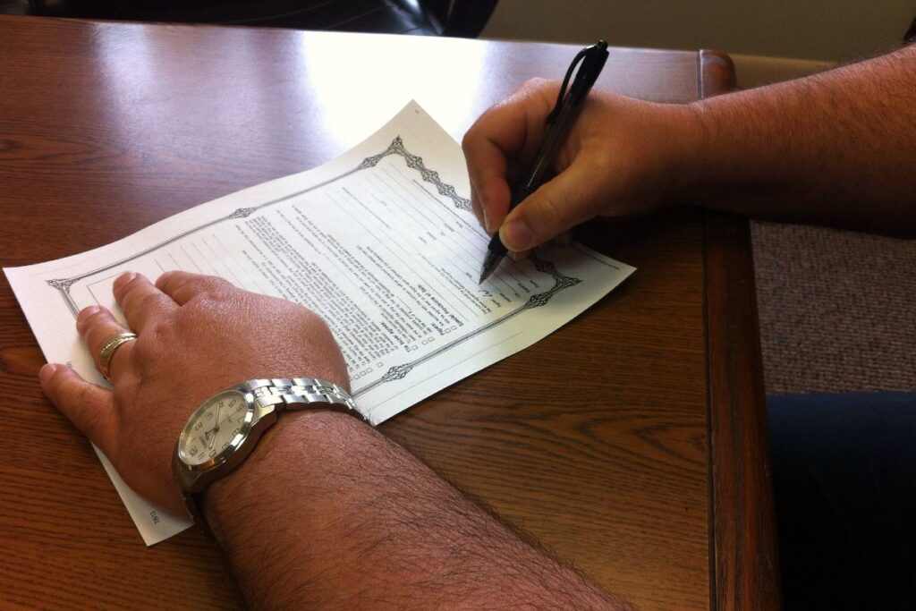 A person signs paperwork