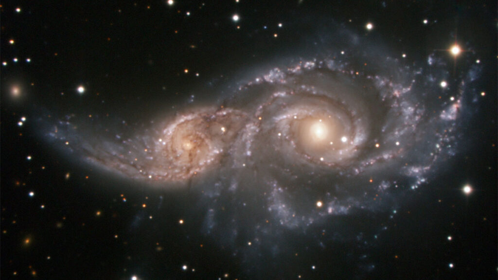 Astronomical photo of two galaxies merging.
