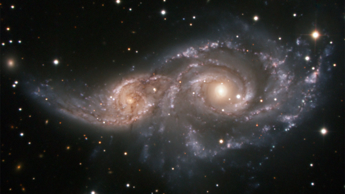 Astronomical photo of two galaxies merging.