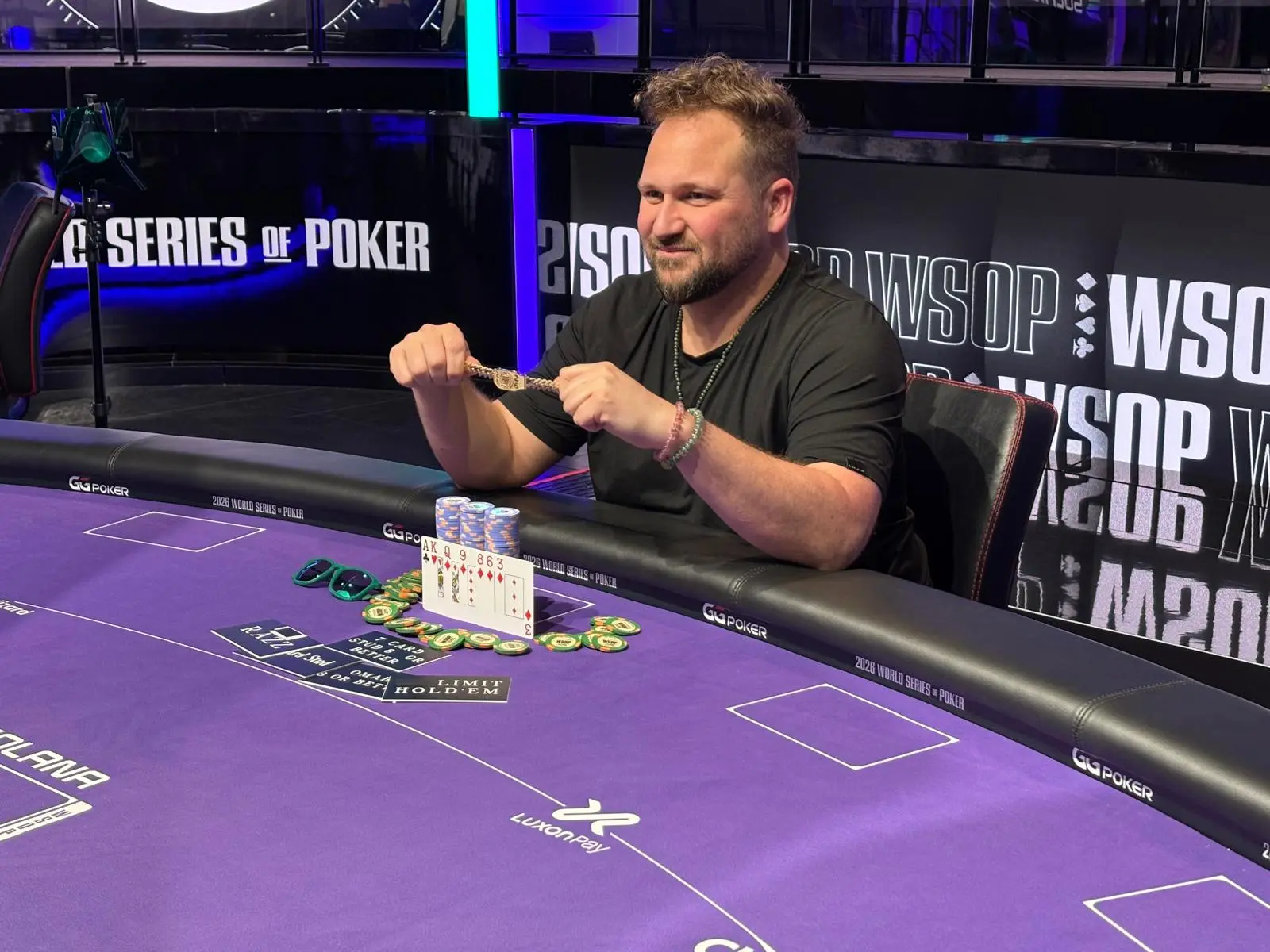 Calvin Anderson sits at a poker table holding a gold bracelet at the 2026 World Series of Poker.