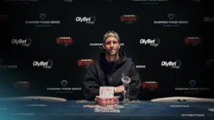 Jonas Kronwitter posing with a trophy and poker chips in front of a Diamond Poker Series backdrop