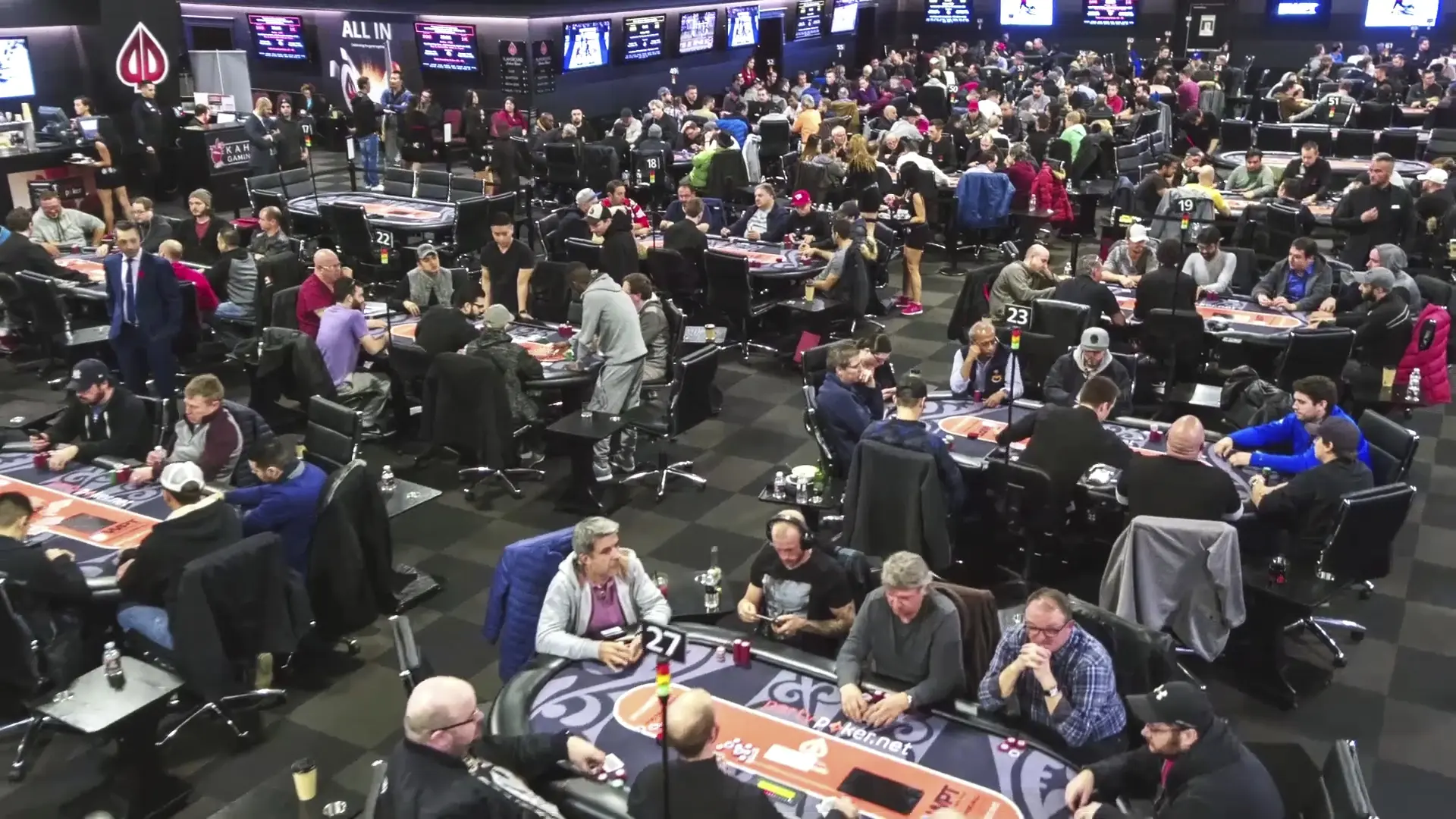 A wide shot of the World Poker Tour tournament floor with players seated at multiple poker tables.